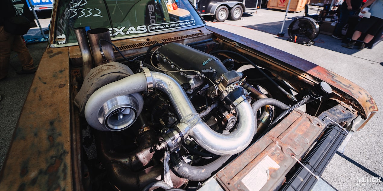 Three Quarters View of a Rusty Car Engine with No Hood on a Sunny Day