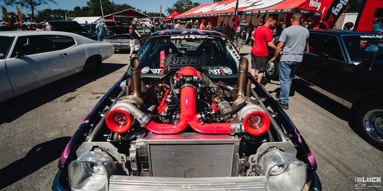Vista delantera de un AMC Pacer con motor turbo doble rodeado de personas en el evento